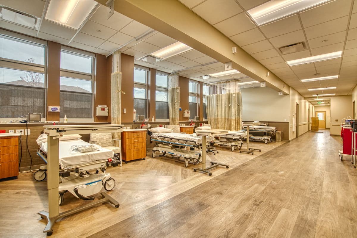 The pre- and post-operative bay, with patient beds by tall windows